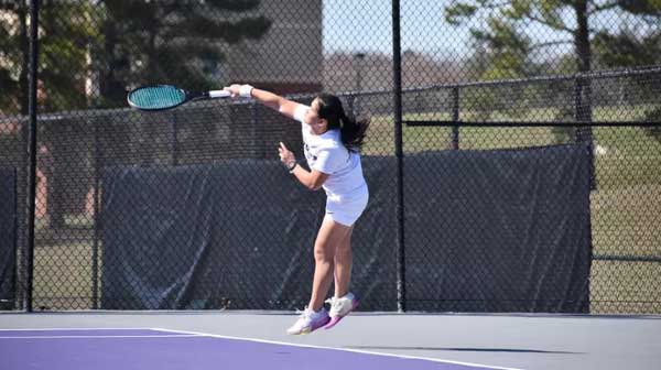 Knights women's tennis player hits the ball during a match. 